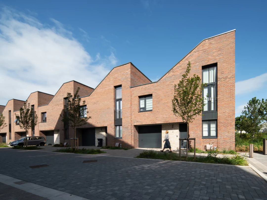 Sunny street view of women walking alongside the homes at The Hangar District.