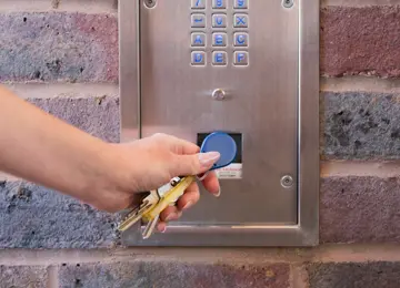 A close up of the apartment door fob featuring a ladies manicured hand.