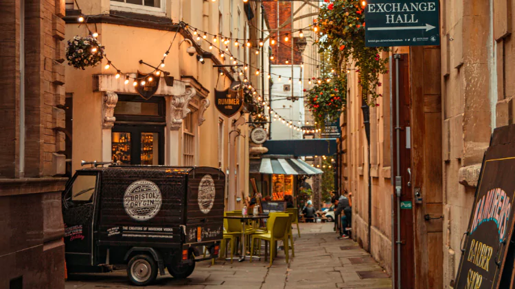 Entrance to St Nicholas Market featuring string outdoor lights and a paved alleyway.