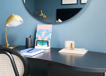 Close up of stylish furnishings on a navy blue desk in a guest bedroom.