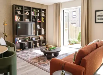 Modern living room featuring a custom TV shelp, orange sofa, patterned rug, and natural light streaming in through open doors.