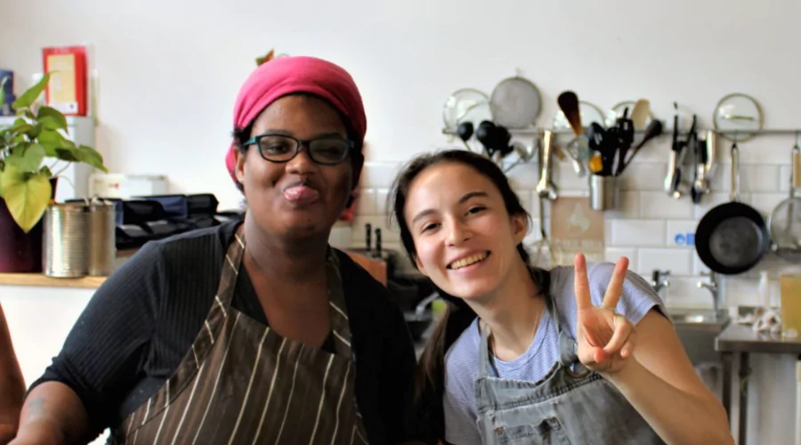 Two young women in a kitchen smiling at the camera