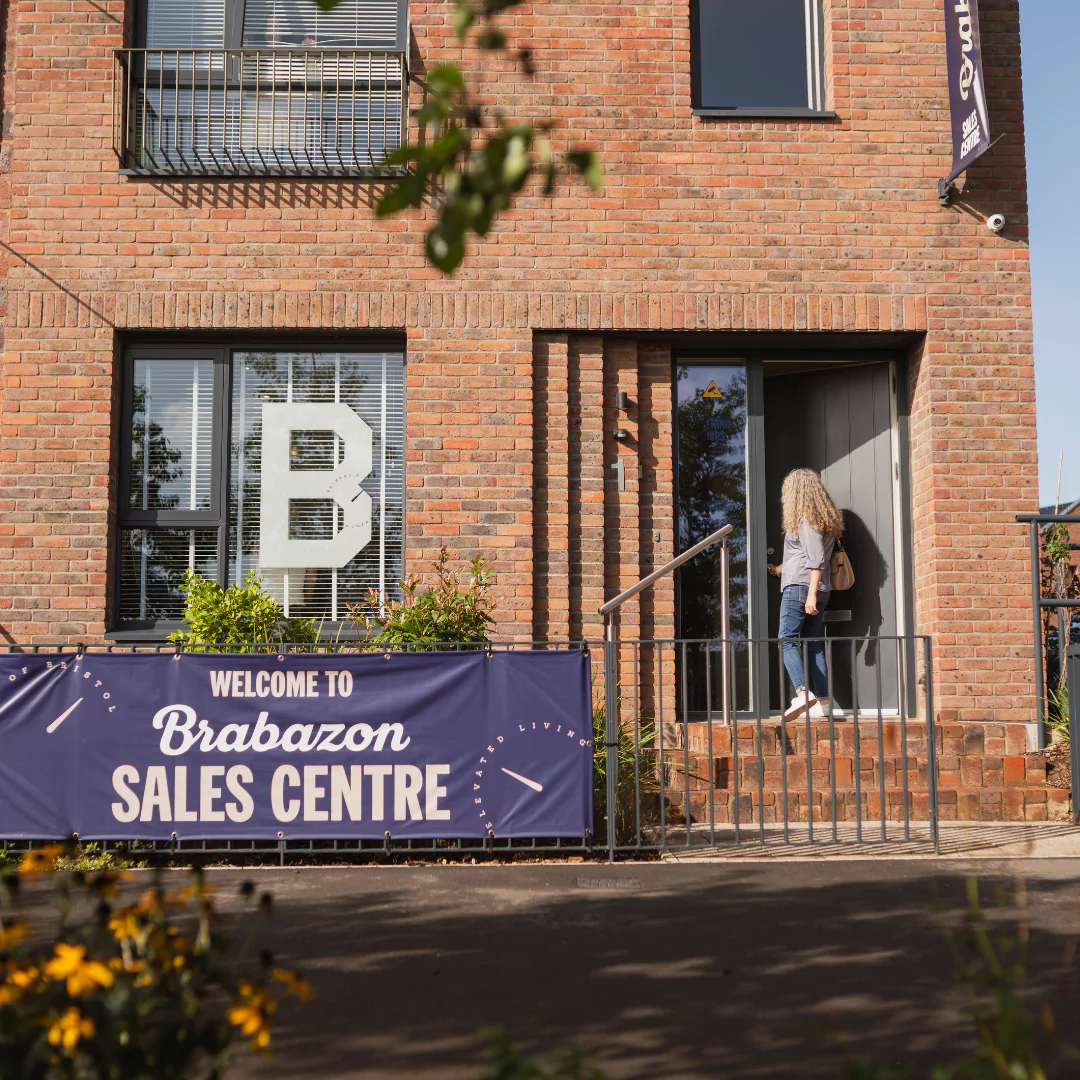 Woman entering the Sales Centre at Brabazon, a modern, brick three-storey terrace house. 