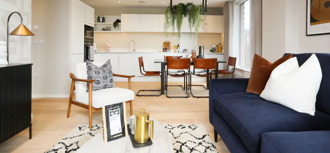 Open-plan kitchen diner with stylish white work tops and a stylish living space.