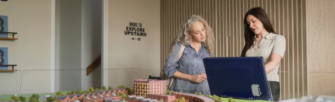 A New Homes Consultant helping a female visitor at The Sales Centre at Brabazon in Bristol.