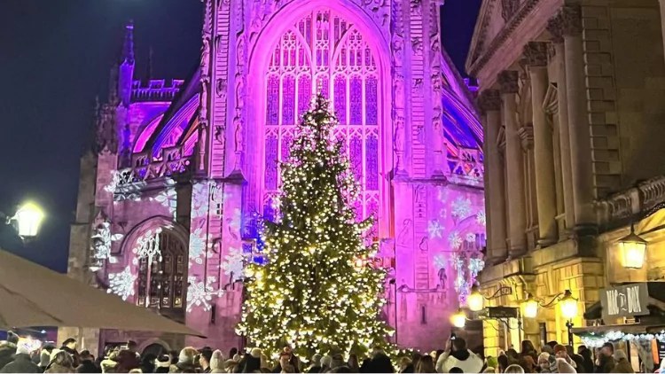 Pictured is Bath Abbey featuring charming cobbled streets and a decorative Christmas tree.