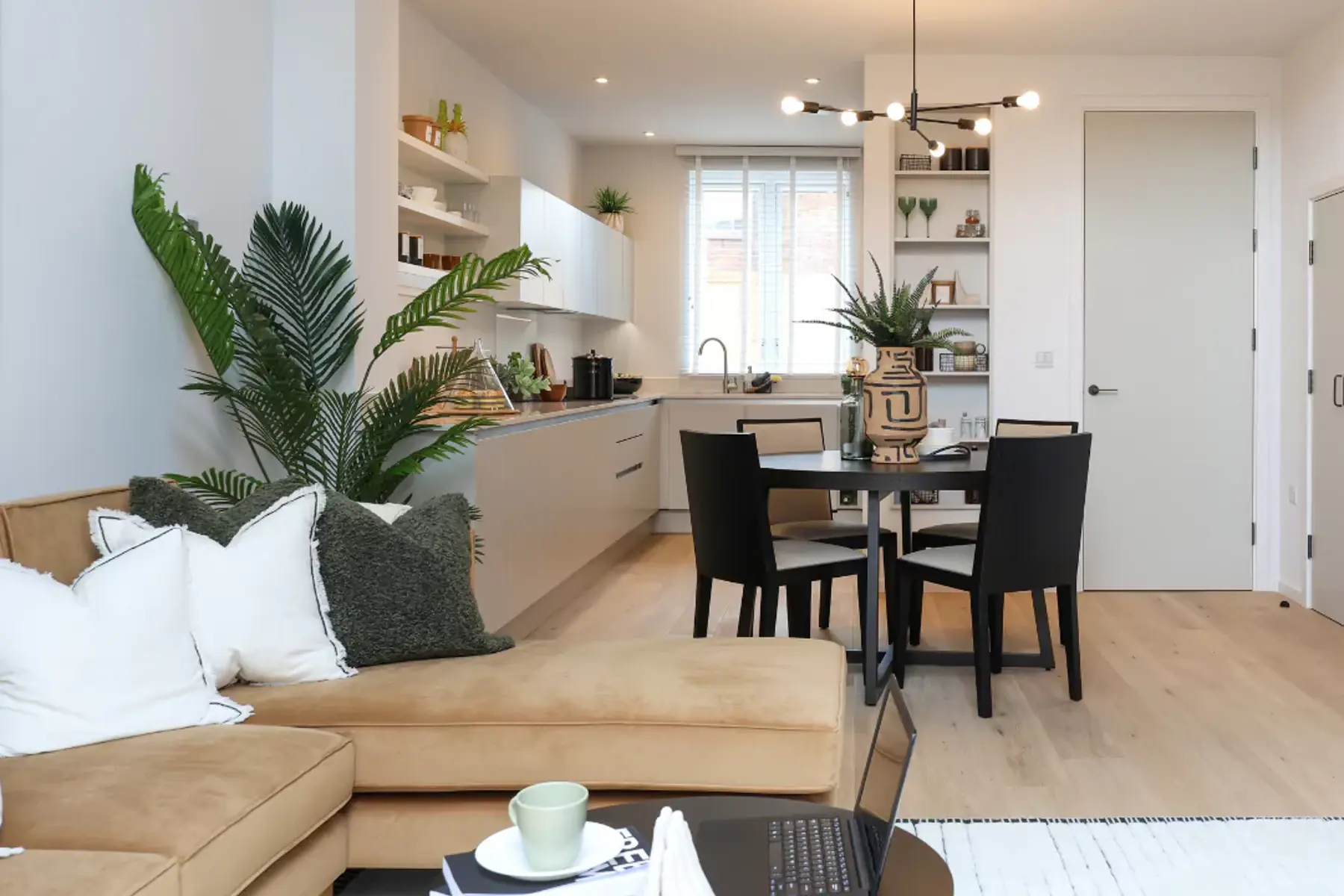 Open-plan living room and kitchen diner flooded with natural light leading in from double height patio doors.