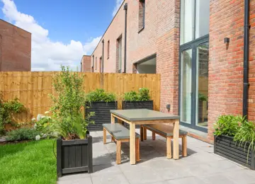 Stylish new build garden, styled with garden furniture, overflowing planters and a grey tone patio area.